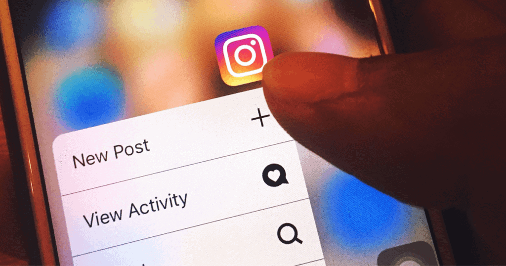 A person is using their thumb to navigate the Instagram app on a smartphone. Tips for using IGTV are available in this post.