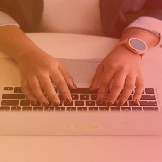 A woman's hands type on a macbook. With our help, learn how to retain and engage your customers with these proven strategies.