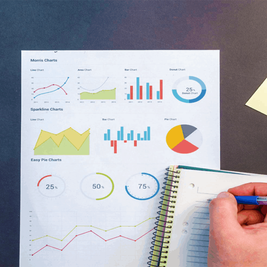 A person works diligently studying graphs and taking notes. Learn how to measure the efficiency of your marketing efforts by focusing on the data that means the most.