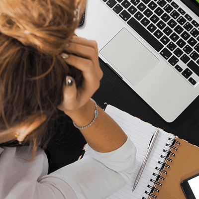 A woman hunched over her computer with her head in her hand. If you're spending a lot of time on your content marketing and it's still failing, here's what you might be doing wrong.